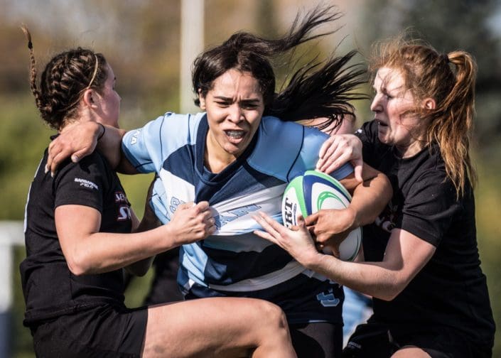 OAKVILLE, ON – NOV. 5, 2016: Sheridan player tries to get past two Seneca defenders at the inaugural OCAA Women’s Rugby Sevens championship. OAKVILLE, ON - NOV. 5, 2016: Sheridan player tries to get past two Seneca defenders at the inaugural OCAA Women's Rugby Sevens championship.